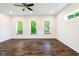 Bedroom featuring multiple windows, ceiling fan, and dark wood floors at 1210 Churchman Ave, Indianapolis, IN 46203