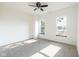 Bedroom with plush carpet, ceiling fan, and two bright windows overlooking the yard at 1210 Churchman Ave, Indianapolis, IN 46203