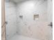 A luxurious shower with beautiful marble tiling and convenient built-in niches for storage at 1210 Churchman Ave, Indianapolis, IN 46203