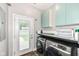 This laundry room features modern washer and dryer, cabinetry, and access to the backyard at 1221 Cottage Ave, Indianapolis, IN 46203