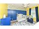 Charming Bedroom featuring bright yellow walls, lemon wallpaper, and a cozy blue rocking chair at 1314 Old Heritage Pl, Greenwood, IN 46143