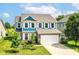 Charming two-story home featuring blue accents, white shutters, well-manicured lawn, and an attached two-car garage at 1314 Old Heritage Pl, Greenwood, IN 46143