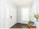 Bright foyer with hardwood floors, white trim, a large window with sheer curtains, and an entryway table with plants at 1314 Old Heritage Pl, Greenwood, IN 46143