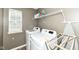 Efficient laundry room with modern white washer and dryer, shelving for storage, and natural light at 1314 Old Heritage Pl, Greenwood, IN 46143