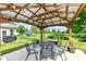 Backyard covered patio featuring an outdoor dining set, a decorative overhead structure, and a serene backyard view at 1314 Old Heritage Pl, Greenwood, IN 46143