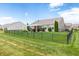 Spacious backyard with well-maintained lawn, black fence, and a patio with white pergola at 13327 Hockley Dr, Fishers, IN 46037