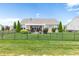 A backyard features a black metal fence, lush lawn, patio with pergola offering outdoor living space at 13327 Hockley Dr, Fishers, IN 46037