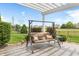 Cozy backyard patio featuring a swing bench and a white pergola, perfect for relaxation at 13327 Hockley Dr, Fishers, IN 46037