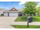 Charming brick home with a three-car garage, a manicured lawn, and established landscaping at 13327 Hockley Dr, Fishers, IN 46037
