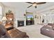 Inviting living room with a fireplace, ceiling fan, and comfortable leather seating at 13327 Hockley Dr, Fishers, IN 46037