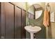 Stylish powder room with modern fixtures, including a pedestal sink and round mirror at 1381 Delacorte Cir, Shelbyville, IN 46176