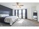 A large primary bedroom with a king bed, ceiling fan, accent wall, and a full length mirror at 1381 Delacorte Cir, Shelbyville, IN 46176