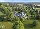 Expansive aerial view of an estate home with manicured lawns and mature trees in a serene setting at 14301 W County Road 300 S, Daleville, IN 47334