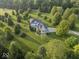 A lush green neighborhood surrounds a sprawling home with long driveways, a private garden, and tall trees at 14301 W County Road 300 S, Daleville, IN 47334