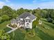 A beautiful aerial view reveals the home's spacious lot, mature trees, and meticulously landscaped grounds at 14301 W County Road 300 S, Daleville, IN 47334