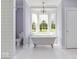 Bright bathroom featuring a clawfoot soaking tub beneath a bay window at 14301 W County Road 300 S, Daleville, IN 47334