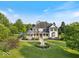 Sprawling home with lush landscaping, a circular driveway, fountain, and inviting front porch at 14301 W County Road 300 S, Daleville, IN 47334