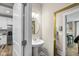 Stylish powder room features a pedestal sink, round mirror with gold frame, and access to the kitchen at 14442 Treasure Creek Ln, Fishers, IN 46038