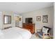 Cozy bedroom features a wooden dresser with TV, sitting chair, and white comforter on the bed at 14442 Treasure Creek Ln, Fishers, IN 46038
