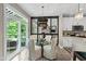 Bright dining area with a glass table, white chairs, and sliding doors to the balcony at 14442 Treasure Creek Ln, Fishers, IN 46038
