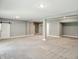 Large basement with neutral carpet and a sliding barn door in the distance at 14474 Treasure Creek Ln, Fishers, IN 46038