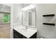 Modern powder room with a single sink vanity, stylish mirror, and a view to a bedroom at 14474 Treasure Creek Ln, Fishers, IN 46038