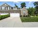 Beautifully landscaped two-story home with a brick and stone facade and a pristine two-car garage at 14474 Treasure Creek Ln, Fishers, IN 46038