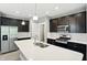 Modern kitchen boasts stainless steel appliances, dark cabinets, white countertops, and center island at 14474 Treasure Creek Ln, Fishers, IN 46038