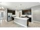 A spacious kitchen with dark cabinets, stainless steel appliances, and a large island with a sink at 14474 Treasure Creek Ln, Fishers, IN 46038