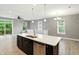 Open concept living area featuring wood floors, kitchen with island, and sliding glass doors to balcony at 14474 Treasure Creek Ln, Fishers, IN 46038