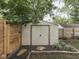 View of a backyard shed in a fenced in area with black landscaping rocks at 1532 E Markwood Ave, Indianapolis, IN 46227