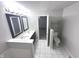 Bright bathroom with double sink vanity, tiled floors, and contemporary lighting fixtures at 1556 N Euclid Ave, Indianapolis, IN 46201