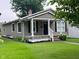 Charming single story home featuring a covered porch and manicured lawn at 1556 N Euclid Ave, Indianapolis, IN 46201