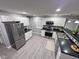 Modern kitchen with stainless steel appliances, white cabinets, and black countertops at 1556 N Euclid Ave, Indianapolis, IN 46201
