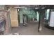 View of the unfinished basement showing a water heater and some installed plumbing at 2157 Sugar Grove Ave, Indianapolis, IN 46202