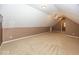 Finished attic space with neutral carpeting, a ceiling fan, and access to other areas at 2325 N Talbott St, Indianapolis, IN 46205