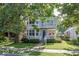 Charming two-story home features a welcoming front porch, balcony, and lush greenery, perfect for suburban living at 2325 N Talbott St, Indianapolis, IN 46205