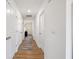 Clean, white hallway with multiple doors and a stylish rug on wood flooring at 24416 Kercheval St, Sheridan, IN 46069