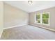 Bright bedroom features neutral paint, carpet, and large windows overlooking a lush yard at 2895 E 600 S, Markleville, IN 46056