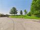 Exterior shot of a rolling green lawn and gravel drive, with outbuildings and home visible at 2895 E 600 S, Markleville, IN 46056