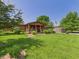 Beautiful log home with a covered porch, mature trees, and an American flag at 2895 E 600 S, Markleville, IN 46056