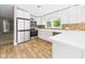 Kitchen with stainless steel fridge and oven, white countertops, and mosaic tile backsplash at 2895 E 600 S, Markleville, IN 46056