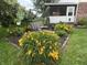 A beautifully landscaped backyard with a cozy swing and a variety of colorful flowers at 2925 Morgan Trl, Martinsville, IN 46151