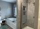Elegant bathroom featuring a soaking tub and a glass-enclosed shower with stylish tile and recessed shelving at 2925 Morgan Trl, Martinsville, IN 46151