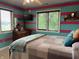 Bright bedroom featuring a queen-sized bed, striped walls, and ample natural light from the window at 2925 Morgan Trl, Martinsville, IN 46151