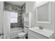 Bright bathroom features tile backsplash, a shower and tub combo and sleek vanity at 3307 N College Ave, Indianapolis, IN 46205
