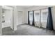 This bedroom features plush carpet, three windows with drapes, and access to other living spaces at 3307 N College Ave, Indianapolis, IN 46205