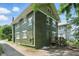 Two-story home boasts a vintage green brick exterior and rear wooden deck at 3307 N College Ave, Indianapolis, IN 46205