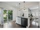 Modern kitchen island featuring a gray countertop and sleek appliances with sliding glass door to backyard at 3307 N College Ave, Indianapolis, IN 46205
