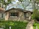 Cozy single-story home featuring a textured facade, large windows, and classic shutters surrounded by mature trees at 3320 E 26Th St, Indianapolis, IN 46218